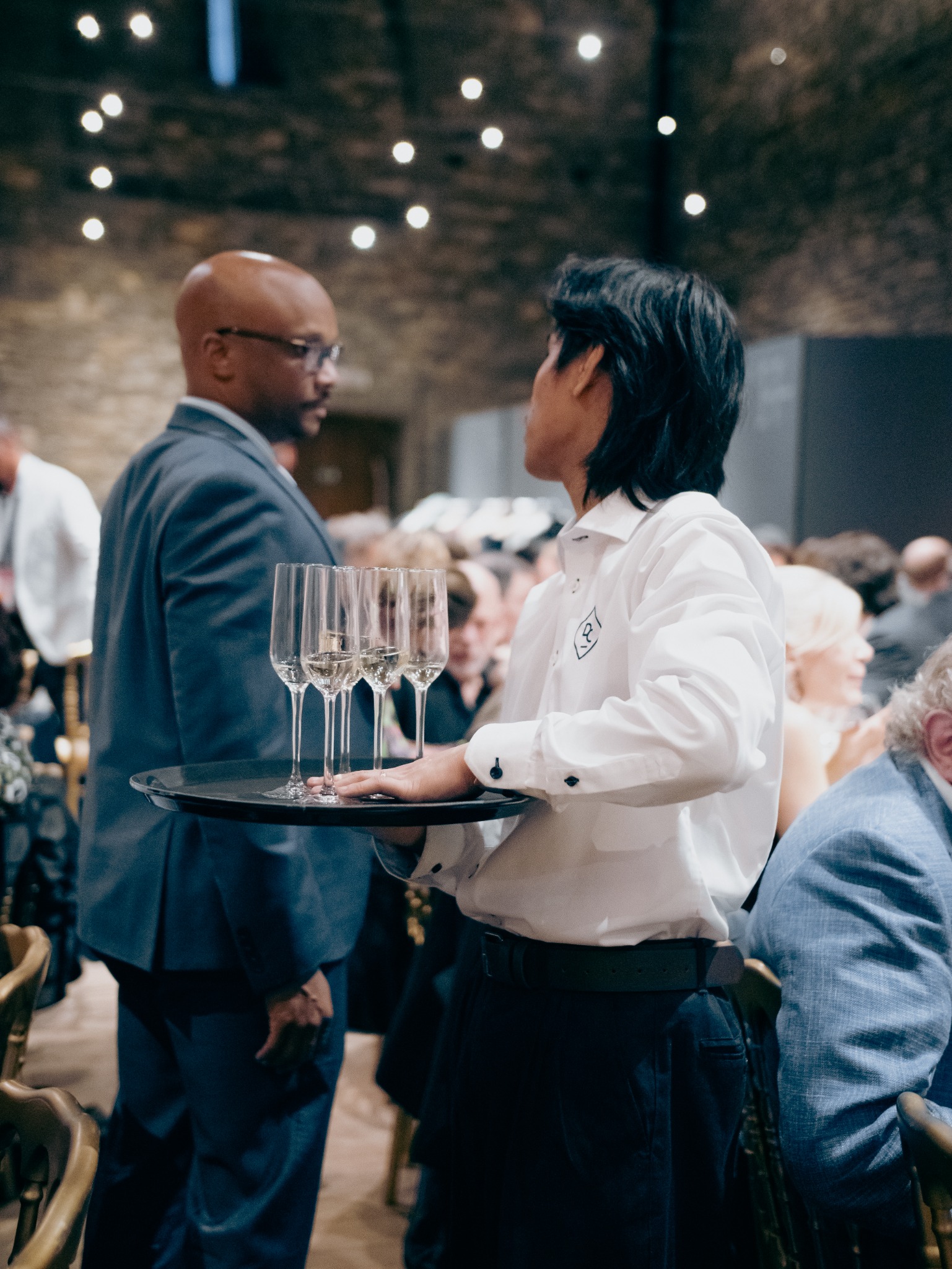 Een medewerker van DC Catering serveert dranken tijdens een sfeervol event