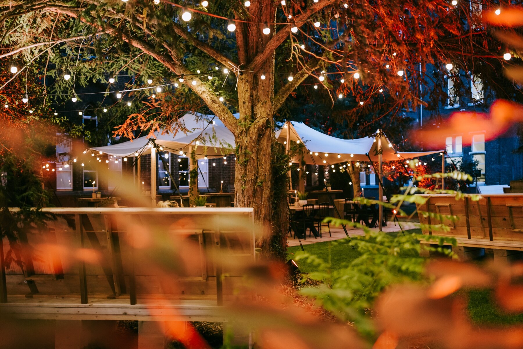 Een sfeervolle tuin met feestverlichting en een gedekte eventlocatie bij avond